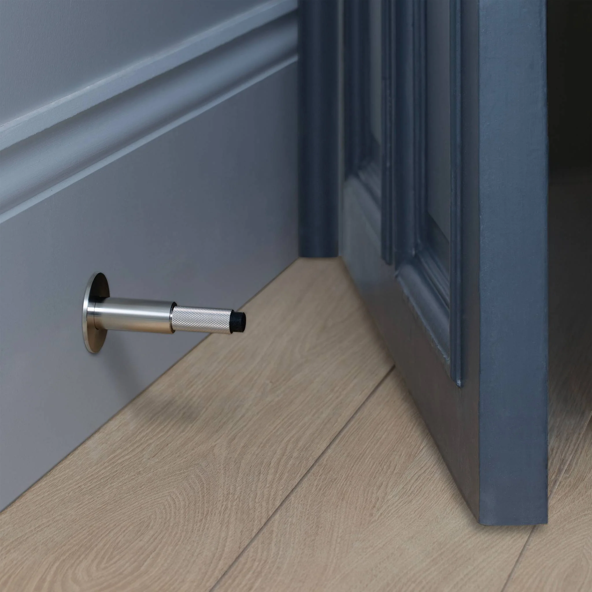 Wall Mounted Door Stop in Solid Metal with Cross Knurl Pattern