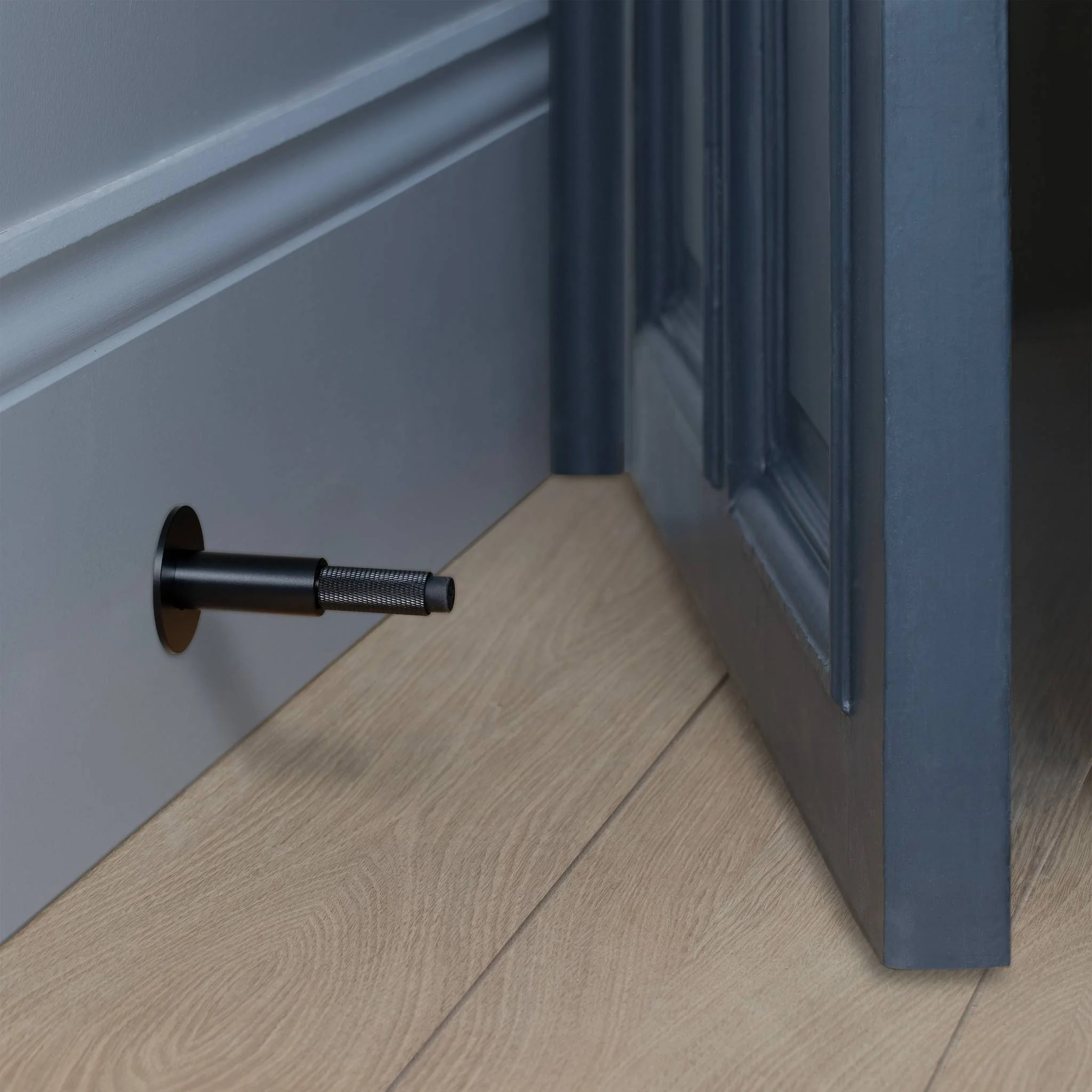 Wall Mounted Door Stop in Solid Metal with Cross Knurl Pattern