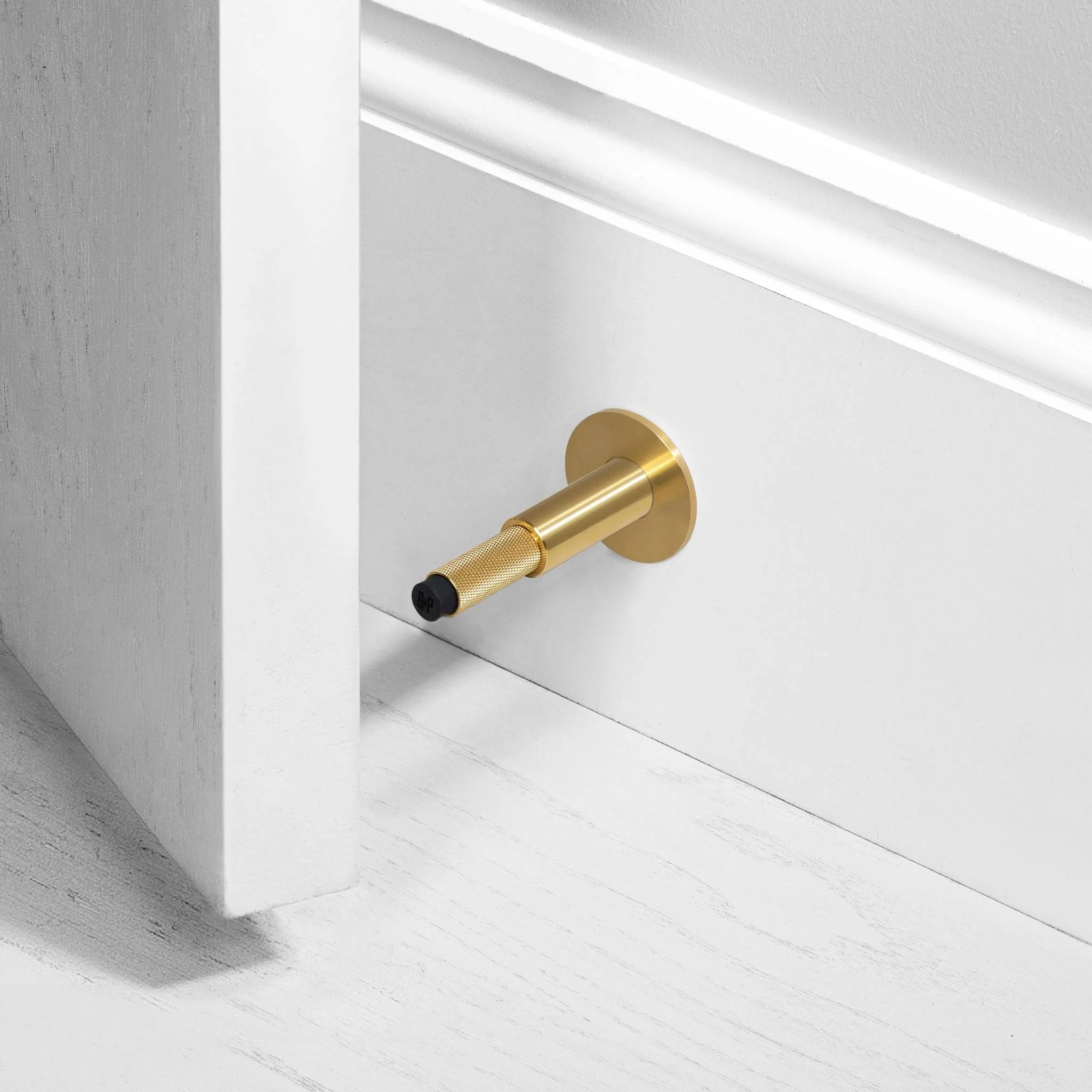 Wall Mounted Door Stop in Solid Metal with Cross Knurl Pattern
