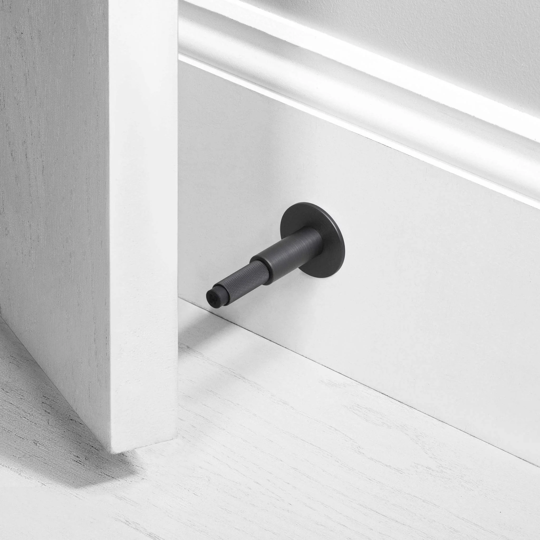 Wall Mounted Door Stop in Solid Metal with Cross Knurl Pattern