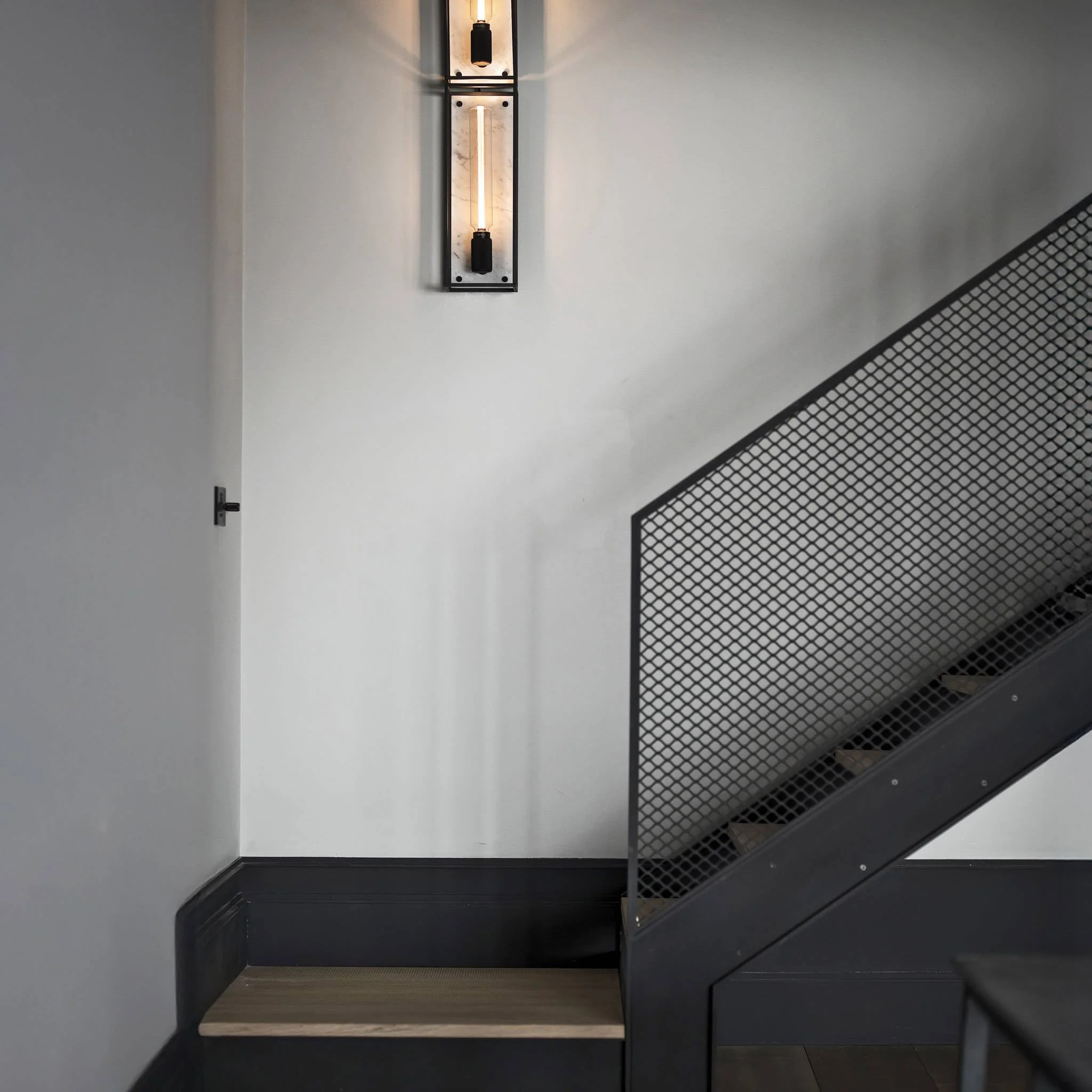 Caged Wall Large Matte Black Wall Light Frames the Buster Bulb