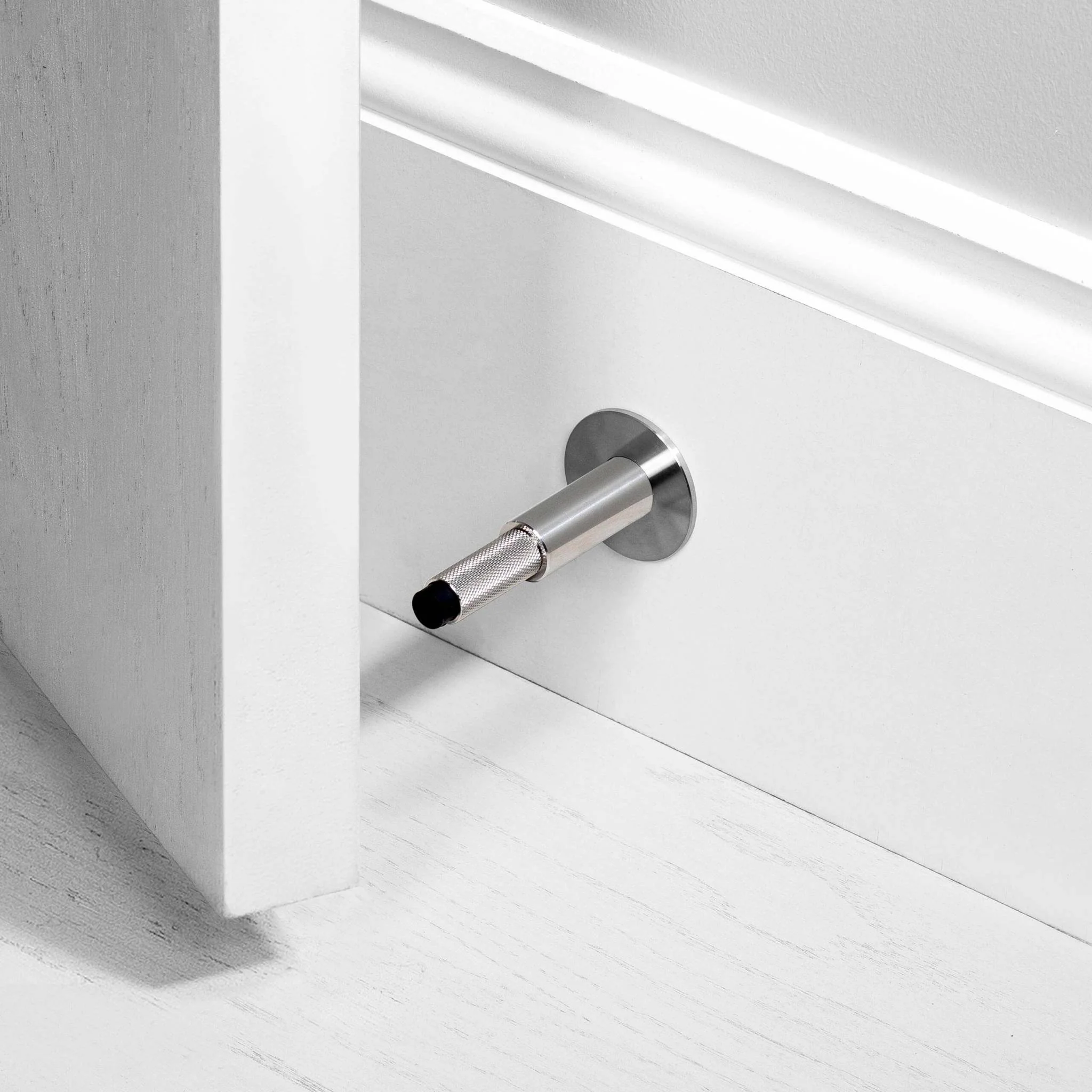 Wall Mounted Door Stop in Solid Metal with Cross Knurl Pattern