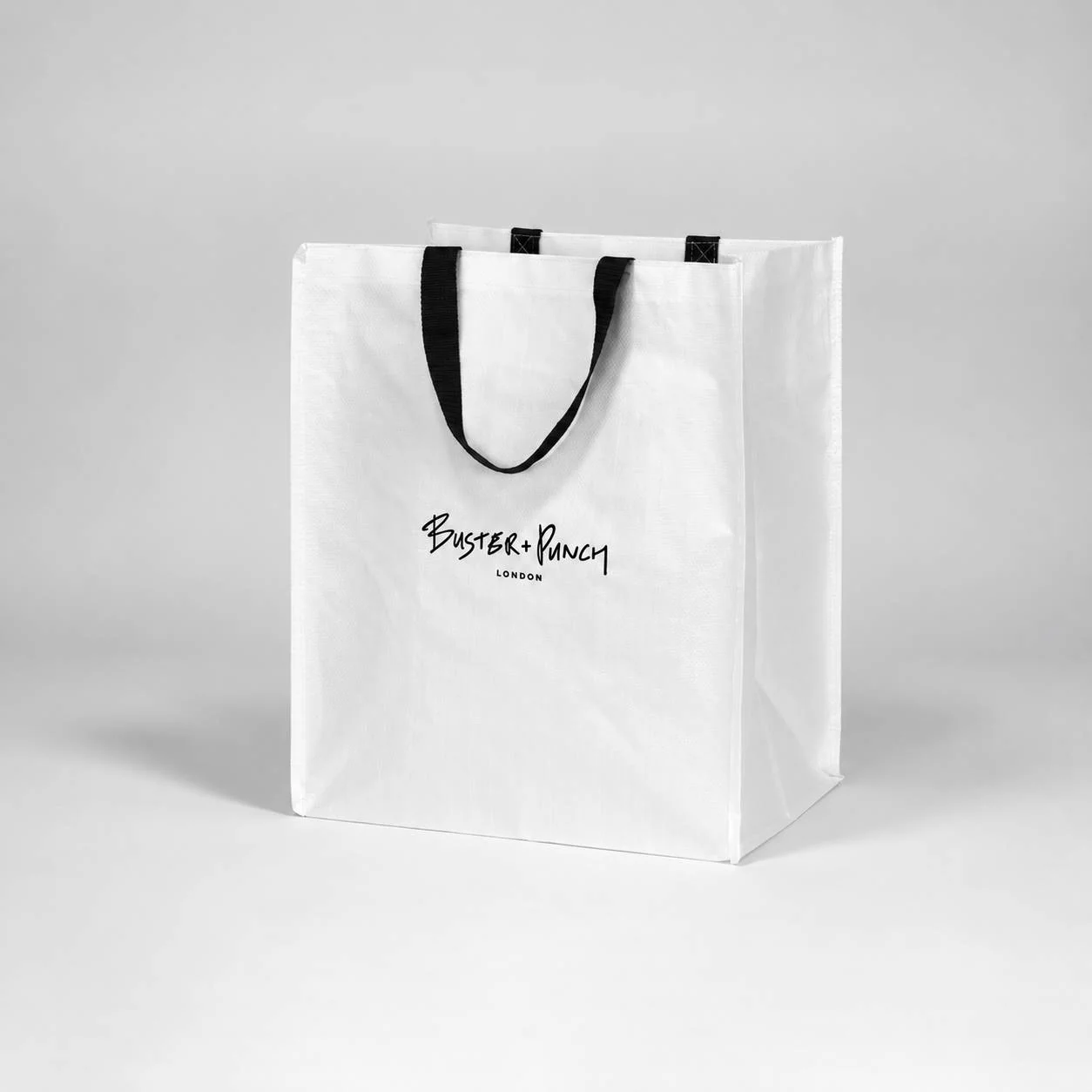 Stor laminert vevd bag B+P med svarte håndtak og London-logo