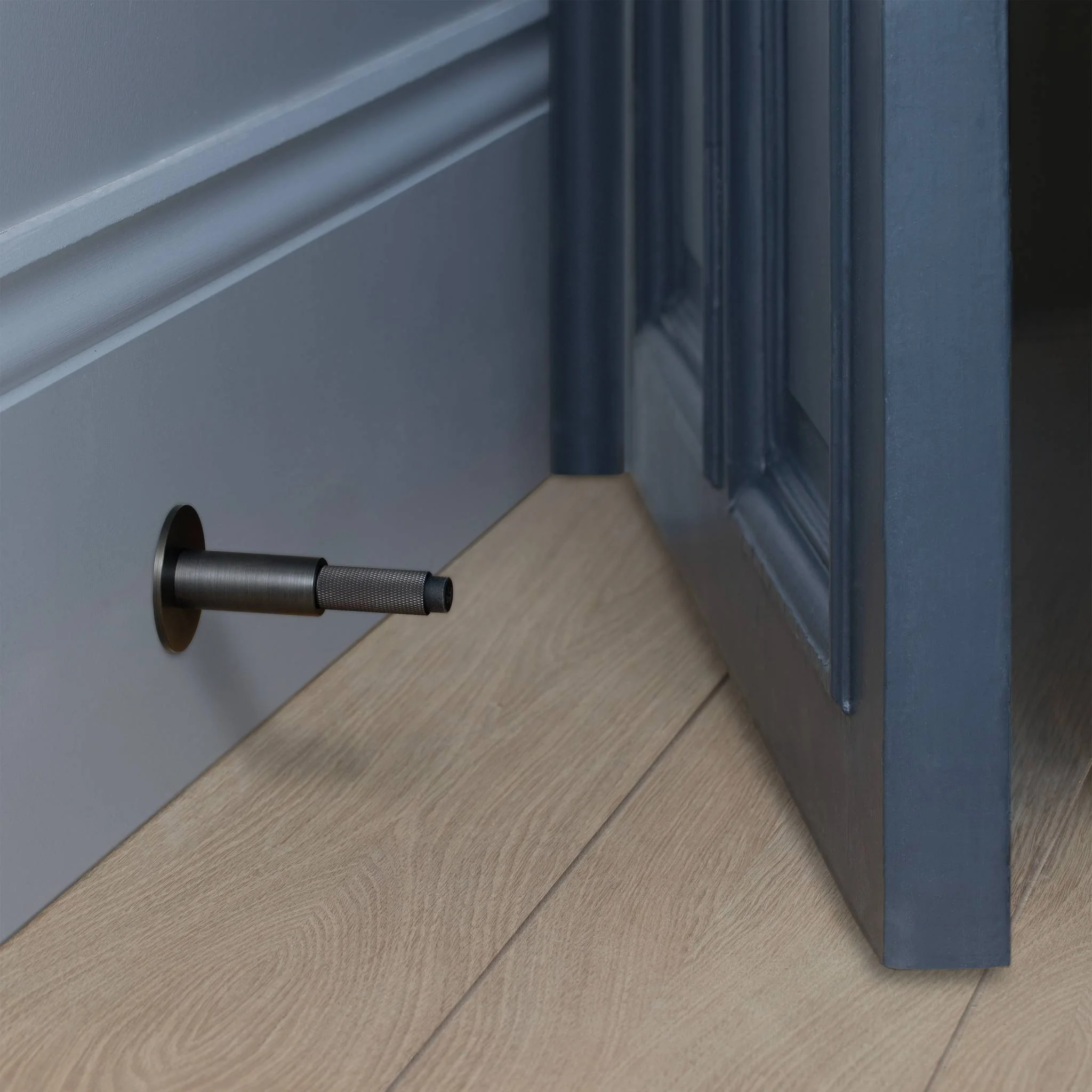 Wall Mounted Door Stop in Solid Metal with Cross Knurl Pattern